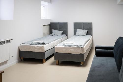 a bedroom with two beds and a couch at Good Night in Warsaw