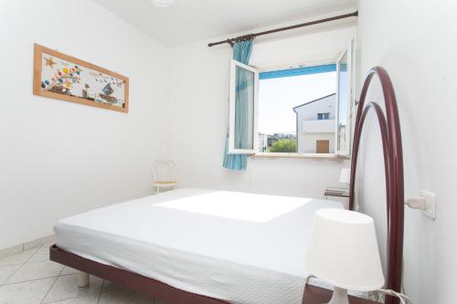 ein weißes Schlafzimmer mit einem Bett und einem Fenster in der Unterkunft RS321 - Marcelli, trilocale fronte mare con spiaggia inclusa in Marcelli