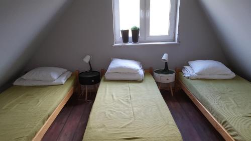 two beds sitting in a room with a window at Domek pod Widetą in Smerek