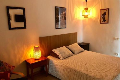 een slaapkamer met een bed en een lamp op een tafel bij Modern & Spacious Studio Isla, Puerto Del Carmen in Tías