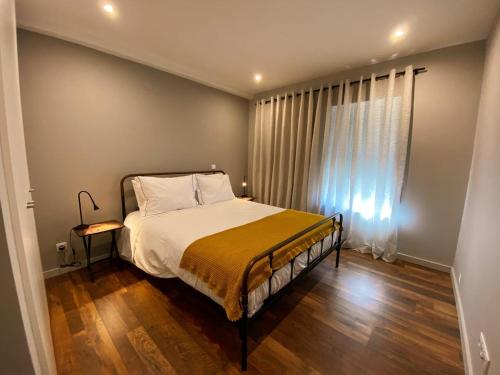 a bedroom with a large bed and a window at Fátima Host 3AP6 in Fátima