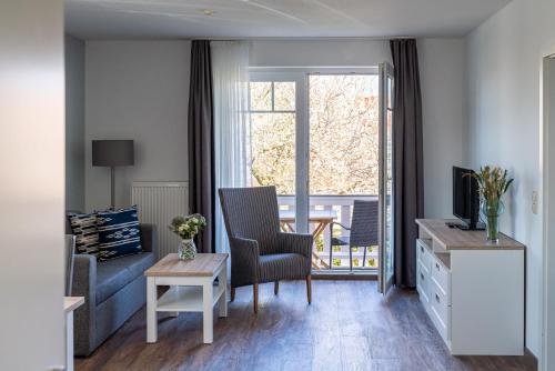 a living room filled with furniture and a window at Strandhafer Aparthotel in Warnemünde