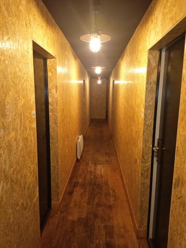 a hallway with a long corridor with wooden floors and a door at Le Relais des Lacs Bourgogne Morvan in Planchez