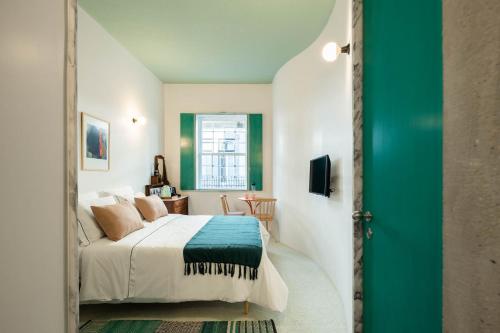 a bedroom with a bed and a green door at Covelo - The Original Rooms and Suites in Amarante