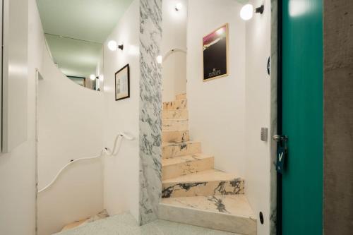 uma casa de banho com escadas em mármore e uma porta verde em Covelo - The Original Rooms and Suites em Amarante