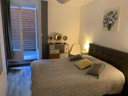 une chambre avec un grand lit et une fenêtre dans l'établissement Avec JARDINET sans vis à vis Plein centre ville au RDC 350m de la plage, à Dieppe