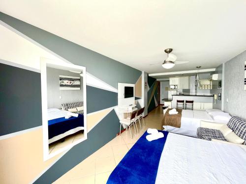 um quarto com 2 camas e uma secretária. em LOFT LUXO VISTA MAR PRAINHA até 5 PESSOAS em Arraial do Cabo
