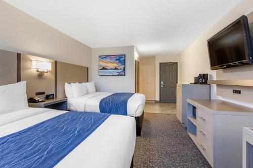 a hotel room with two beds and a flat screen tv at Comfort Inn San Diego Miramar in Miramar