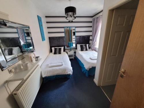 mały pokój z 2 łóżkami i lustrem w obiekcie Tamarind Cove & Barrons Hotel w Blackpool
