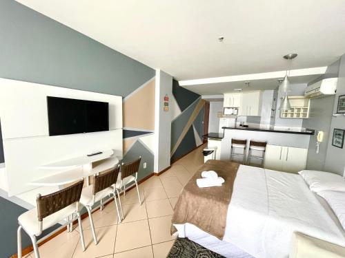 um quarto com uma cama grande e uma cozinha em LOFT LUXO VISTA MAR PRAINHA até 5 PESSOAS em Arraial do Cabo