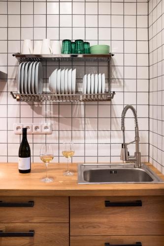 a kitchen with a sink and two glasses of wine at Žabinec - penzion, vinotéka in Kurdějov