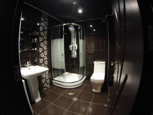 a bathroom with a shower and a toilet and a sink at Hotel Grand Palace in Akhaltsikhe