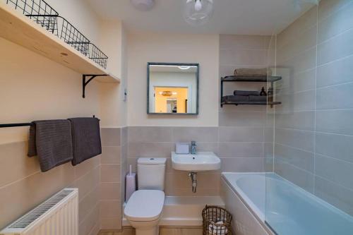 a bathroom with a toilet and a sink and a bath tub at Number 27, Swanpool in Falmouth