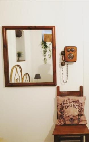 a mirror on a wall with a chair and a lamp at Il nido di Lele e Schina in Arvier
