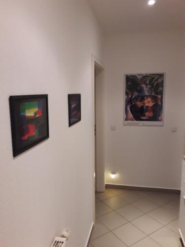 a hallway with three paintings on the wall at Ferienwohnung Chemnitz - Kaßberg in Chemnitz