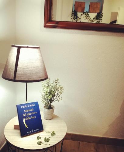 a table with a lamp and a book on it at Il nido di Lele e Schina in Arvier