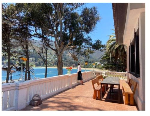 a woman standing on a balcony looking at the water at Casa Wilson in Zapallar