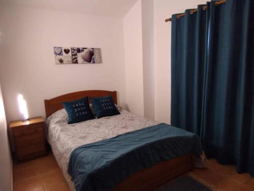 サン・ペドロ・デ・モエルにあるLilly Beach Houseのベッドルーム1室(青いカーテン付きのベッド1台付)