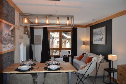 a living room with a table and a couch at Appartement Standing 5* Arc 1950 in Arc 1950