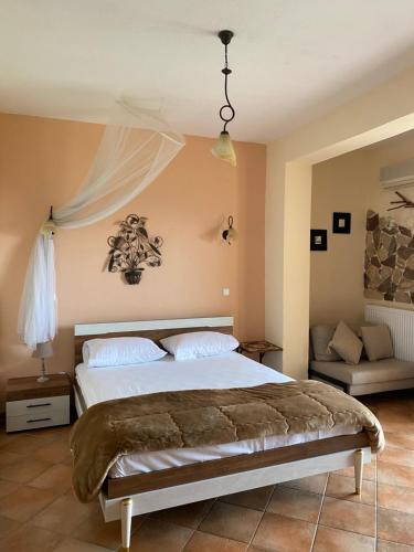 una camera con un grande letto e un divano di Guesthouse Kerkinitis a Lithótopos