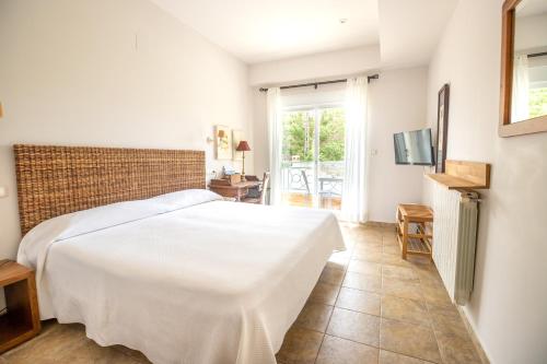 a bedroom with a white bed and a balcony at Hotel Noguera Mar in Denia