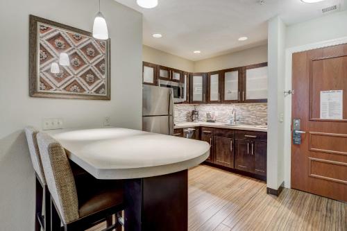 a kitchen with a white counter top and wooden cabinets at Staybridge Suites Baltimore - Inner Harbor by IHG in Baltimore