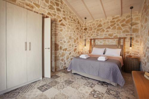 a bedroom with a bed and a stone wall at Villa Sirina in Magaziá