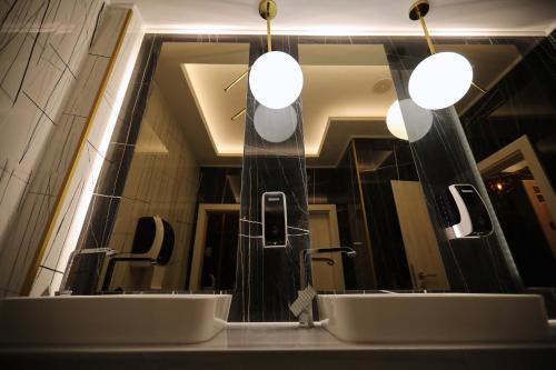 - une salle de bains avec deux lavabos en face d'un miroir dans l'établissement Hotel Grand Dedal, à Mamaia Nord – Năvodari
