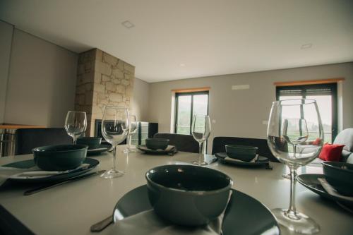 a table with wine glasses and plates on it at Lamegos GuestHouse - Gerês in Terras de Bouro