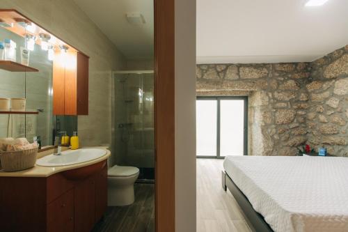 ein Badezimmer mit einem Bett, einem Waschbecken und einer Toilette in der Unterkunft Lamegos GuestHouse - Gerês in Terras de Bouro