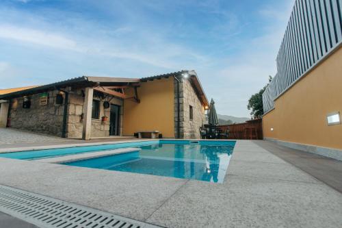 a swimming pool in front of a building at Lamegos GuestHouse - Gerês in Terras de Bouro