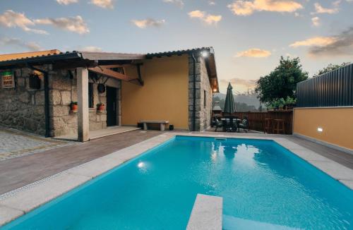 a swimming pool in front of a house at Lamegos GuestHouse - Gerês in Terras de Bouro