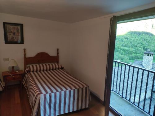 1 dormitorio con 1 cama y balcón en Centro Torla-Ordesa 5pax Apto Miguel en Torla