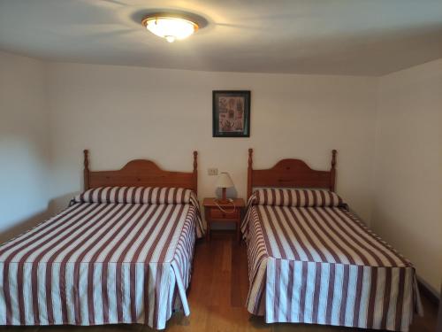 two beds in a small room with two at Centro Torla-Ordesa 5pax Apto Miguel in Torla