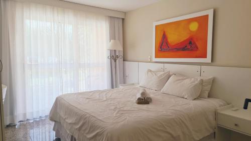 a bedroom with a bed and a painting on the wall at KS Beach Hotel in Rio de Janeiro