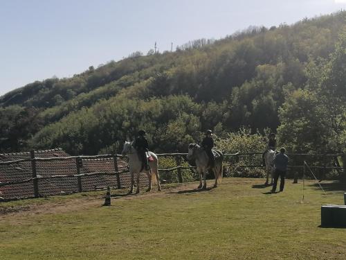 a group of people riding horses in front of a fence at Casina Matilde in Varese Ligure
