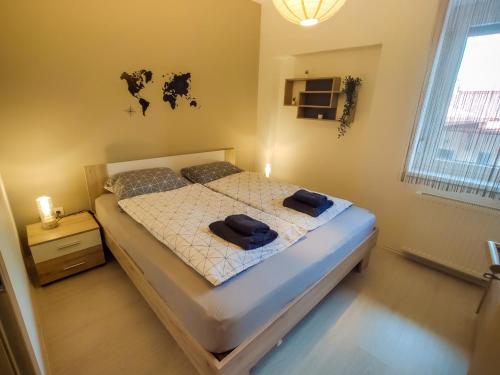 1 dormitorio con 1 cama con 2 toallas en Trika Apartman, en Sárvár