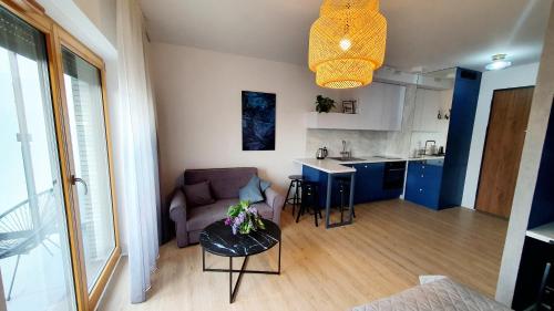 a living room and kitchen with a couch and a table at Apartament Dobra Fala in Gdańsk