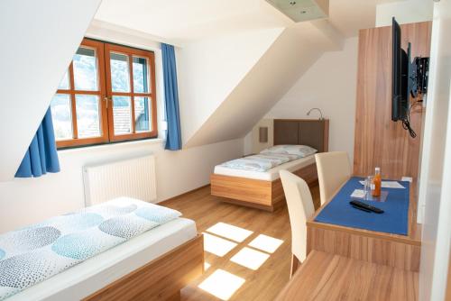 een kamer met 2 bedden en een tafel met een bureau bij Gästehaus Schütz in Spitz