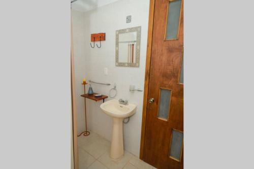 ein Badezimmer mit einem Waschbecken und einer Holztür in der Unterkunft Hacienda Cariño de la Montaña 3000 m2 exclusivos in Tlahuapan