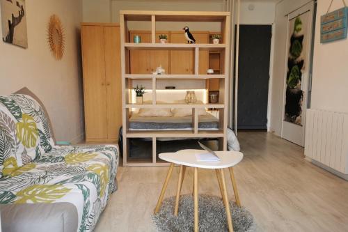 ein Wohnzimmer mit einem Sofa und einem Tisch in der Unterkunft Appartement cosy Roscoff 50 m plage thalasso WIFI PARKING in Roscoff