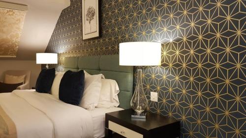 a bedroom with a bed and two lamps on a table at Number Four at Stow in Stow on the Wold