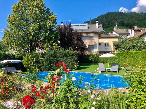 um jardim com piscina e um edifício em Garni Hotel Tauber em Bressanone