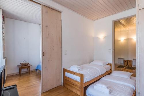 une chambre avec deux lits et un miroir dans l'établissement Appartement du Mont - Résidence La Vardaffe - Welkeys, à Chamonix-Mont-Blanc