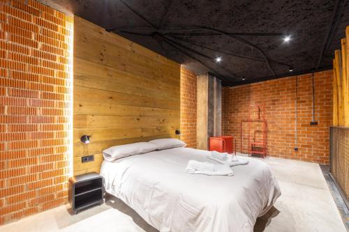 a bedroom with a large bed in a brick wall at ART LOFTS Valencia by Benisur in Valencia