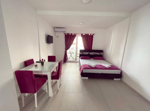 Schlafzimmer mit einem Bett und einem Tisch sowie einem Tisch und Stühlen in der Unterkunft Apartmani Agi in Budva