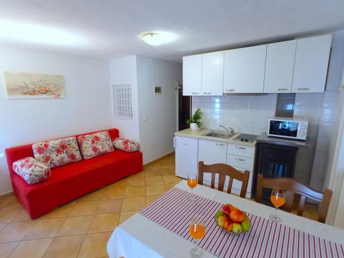 a living room with a red couch and a table at Old Town Vrsar, apartments Danica & Zoran in Vrsar