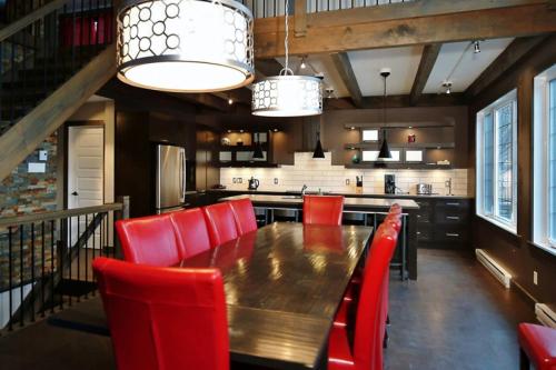 a dining room with a table and red chairs at 14- Chalet à louer à Stoneham in Stoneham