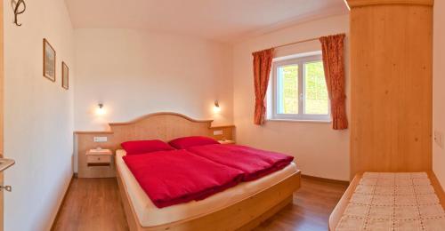 ein Schlafzimmer mit einem Bett mit einer roten Decke in der Unterkunft Unterstoan Hof in Tramin an der Weinstraße