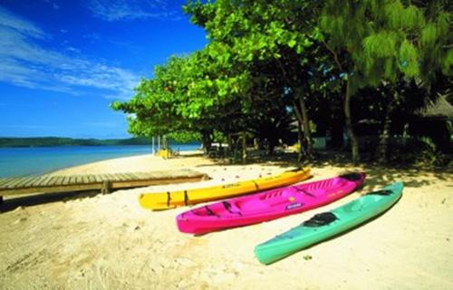 four kayaks are lined up on a beach at Tongan Beach Resort in Utungake